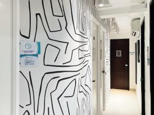a hallway with black and white graffiti on the wall at Student Accommodation - 5 Man Cheong Street in Hong Kong