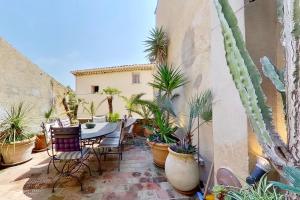 a patio with a table and chairs and potted plants at La Maison du Prince in Grimaud