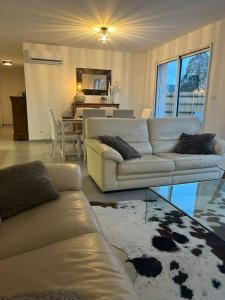 a living room with two couches and a dining room at La Villa Coquette in Vouvray