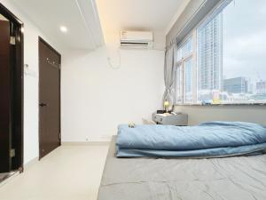 a bedroom with a blue bed and a window at Student Accommodation - 5 Man Cheong Street in Hong Kong