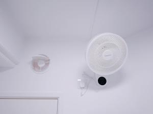 a white fan is on a white wall at Student Accommodation - 5 Man Cheong Street in Hong Kong