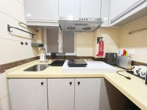 a kitchen with white cabinets and a sink at Student Accommodation - 5 Man Cheong Street in Hong Kong