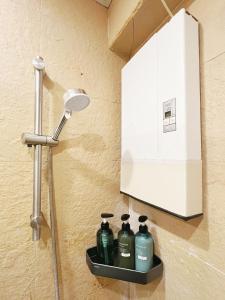 a bathroom with a shower with a shelf with bottles at Student Accommodation - 5 Man Cheong Street in Hong Kong