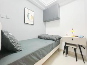 a small white bedroom with a bed and a desk at Student Accommodation - 5 Man Cheong Street in Hong Kong