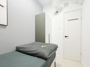 a small room with a bed and a door at Student Accommodation - 5 Man Cheong Street in Hong Kong