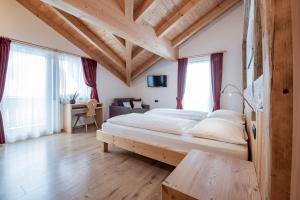 ein Schlafzimmer mit einem großen Bett in einem Zimmer in der Unterkunft Rifugio La Para in St. Vigil