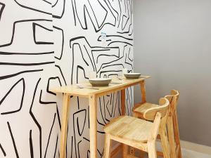 a table and chairs with a black and white patterned wall at Student Accommodation - 5 Man Cheong Street in Hong Kong