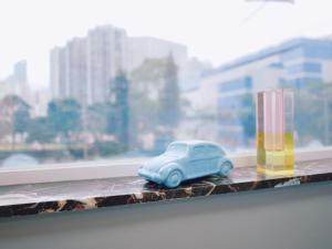 un pequeño coche de juguete azul sentado en un alféizar de la ventana en Student Accommodation - 5 Man Cheong Street en Hong Kong