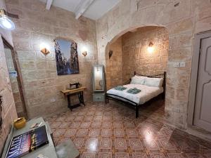 a bedroom with a bed in a stone walled room at Central Valletta Townhouse with Maltese Balcony in Valletta