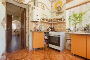 a kitchen with orange cabinets and a stove top oven at Kyzyl-Armeyskaya Guest House in Kazan