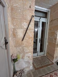 a brick wall next to a door with a window at Central Valletta Townhouse with Maltese Balcony in Valletta