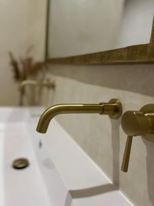 a bathroom sink with a gold faucet at La Suite du clocher in Noves +8 photos