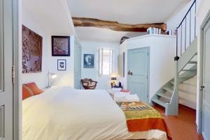 a bedroom with a large bed and a staircase at La Maison du Prince in Grimaud