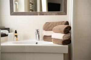 a bathroom with a white sink and towels at Frühstückspension Auer - Haus Kargl in Schladming