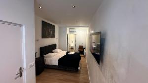 niewielka sypialnia z łóżkiem i telewizorem w obiekcie Stylish studio in the heart of Breda city center w mieście Breda