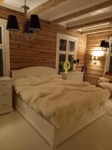 1 cama blanca grande en una habitación con paredes de madera. en Kuivakangas, en Kuivakangas