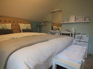 a bedroom with a large bed with white sheets at B&B Le Club de la Source in Hannut