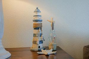 Una mesa con un faro y una botella. en Appartement Wijde Blick 110 - aan de duinen - Callantsoog, en Callantsoog