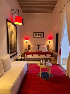 a bedroom with a bed and a red rug at RIAD ENNAFOURA BOUTIQUE HOTEL in Marrakech