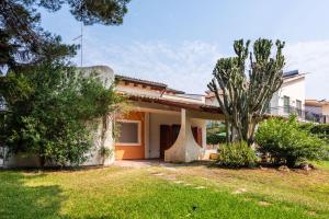 a house with a palm tree in the yard at Casa nel Verde a Fontane Bianche by Wonderful Italy in Siracusa