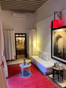 a bedroom with a white bed and a table at RIAD ENNAFOURA BOUTIQUE HOTEL in Marrakesh