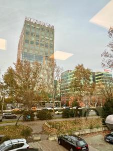 un parking avec des voitures garées devant un grand bâtiment dans l'établissement Appa Hostel, à Zagreb