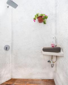 a bathroom with a sink with a potted plant on the wall at Liem Hostel Malioboro in Sentool
