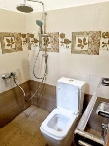 uma casa de banho com um WC e um chuveiro em JAYANDRA HOLIDAY BUNGALOW 