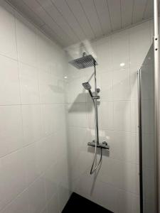 a bathroom with a shower in a white wall at Kotimaailma apartments#2 Uusi kaksio keskustassa in Seinäjoki