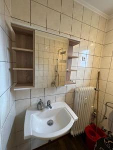 La salle de bains est pourvue d'un lavabo blanc et d'un miroir. dans l'établissement Secrets Design Apartment, à Rodenbach