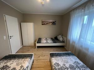 - une chambre avec 2 lits dans une chambre avec une fenêtre dans l'établissement Secrets Design Apartment, à Rodenbach