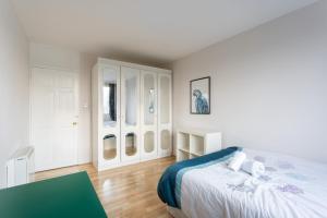 ein weißes Schlafzimmer mit einem Bett und einem Tisch in der Unterkunft Deluxe room with lovely lake View in London