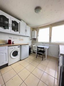 uma cozinha com uma máquina de lavar roupa e uma mesa em Deluxe room with lovely lake View em Londres