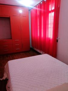 a red bedroom with red cabinets and a bed at Ruiz Domicile in Kawit