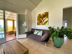 a living room with a couch and a table at Villa détente vue mer st leu 6 personnes in Saint-Leu