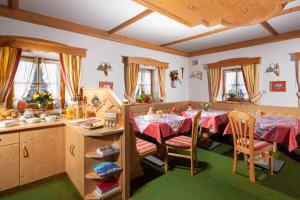 a dining room with two tables and a kitchen at Pension Rennlehen Ferienwohnungen in Berchtesgaden