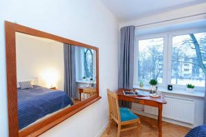 1 dormitorio con cama y escritorio con espejo en Bright and elegant apartment in the green area!, en Varsovia