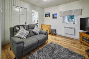 a living room with a couch and a television at Host & Stay - Camwy Cottage in Brynsiencyn