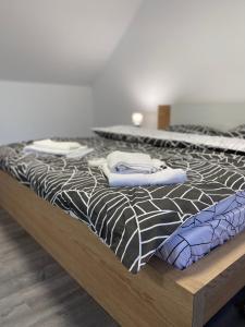 a bed with black and white sheets and pillows on it at Sunny Hill Apartments in Sînpetru