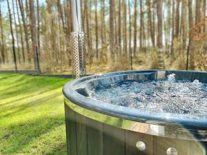 a hot tub filled with water in a yard at LEŚNA STODOŁA in Łubiana
