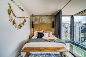 a bedroom with a bed and a large window at Divine 1BR PH Tulum w Private Pool, Cenote, Gym in Tulum +38 photos