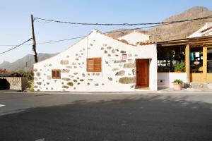 un edificio blanco al lado de una calle en Vv Casa Frasquita en San Bartolomé