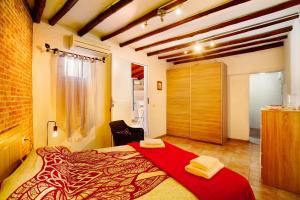1 dormitorio con 1 cama con manta roja en Vv Casa Frasquita en San Bartolomé