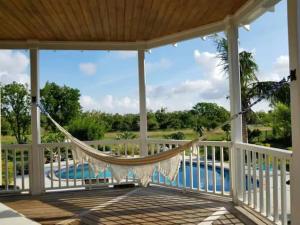 a hammock on a porch with a view of a pool at Lakeview bed & breakfast in Freeport