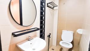 La salle de bains est pourvue d'un lavabo et d'un miroir. dans l'établissement The Best Hotel in Bayan Lepas - THE LOV PENANG, à Bayan Lepas