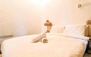 Una cama blanca con una toalla encima. en The Best Hotel in Bayan Lepas - THE LOV PENANG, en Bayan Lepas