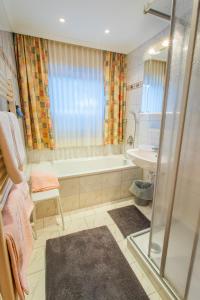 a bathroom with a shower and a tub and a sink at Bergerhof in Ramsau am Dachstein