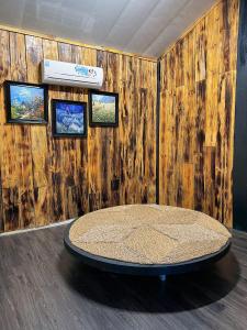 a room with a table in front of a wooden wall at Thênh Thang Home & Cafe in Mộc Châu