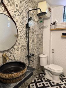 a bathroom with a tub and a toilet and a mirror at Thênh Thang Home & Cafe in Mộc Châu