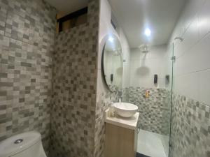 a bathroom with a sink and a toilet and a mirror at Maidy Luxury in Medellín